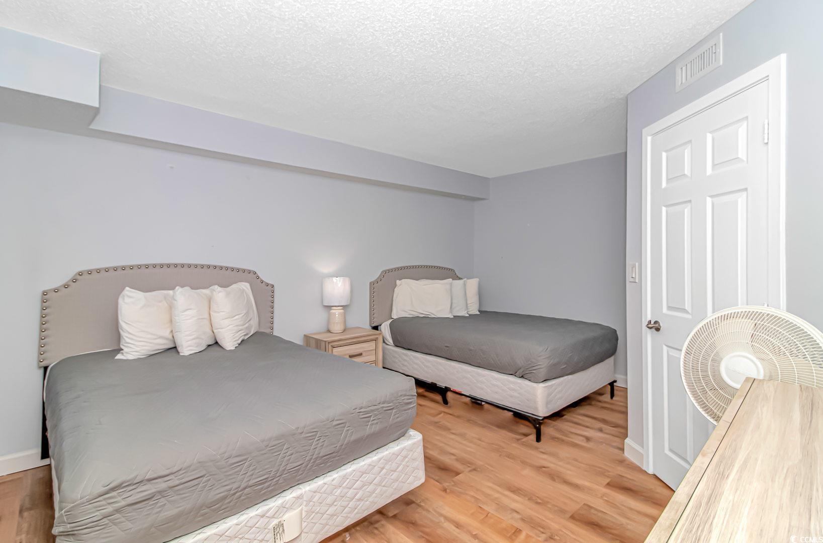 1708 North Ocean Boulevard, Unit PH1 Myrtle Beach, SC 29577 - Photo 13 of 26 Bedroom with a textured ceiling and light wood-sty