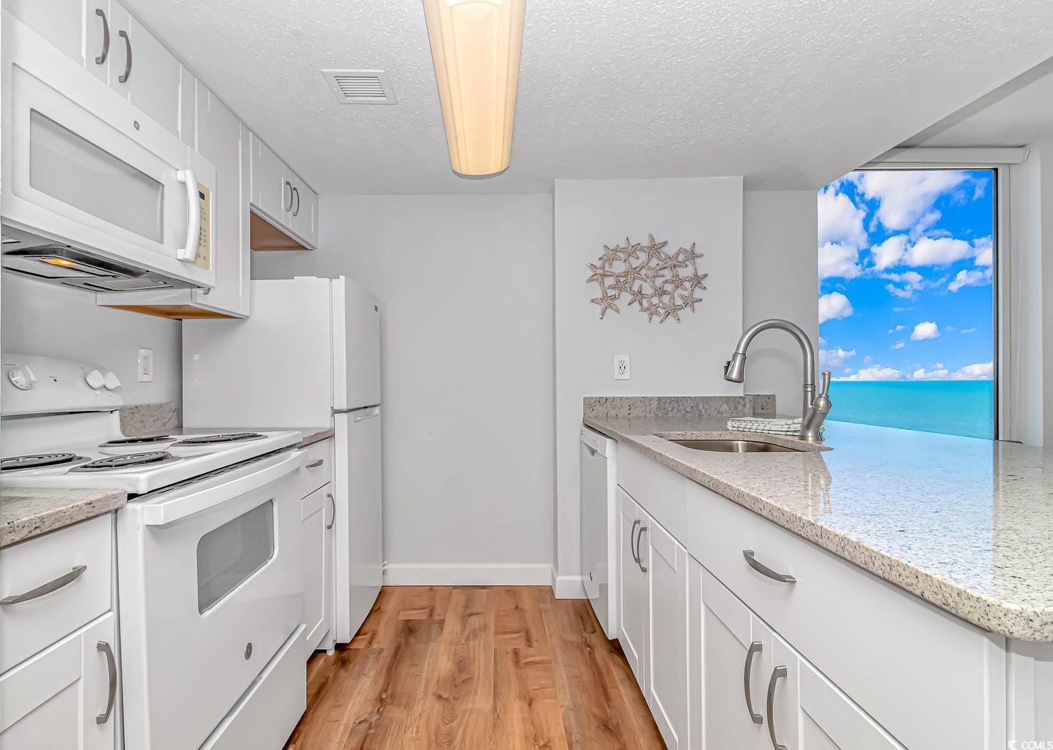 1708 North Ocean Boulevard, Unit PH1 Myrtle Beach, SC 29577 - Photo 4 of 26 Kitchen featuring white appliances, a peninsula, w