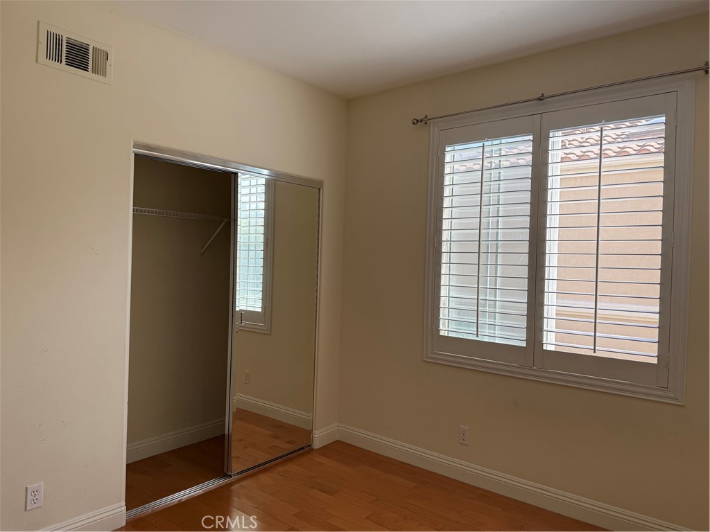 16 Del Ventura Irvine, CA 92606 - Photo 11 of 15 a view of an empty room with wooden floor and a window