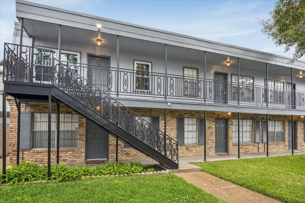 a view of house with a yard and balcony