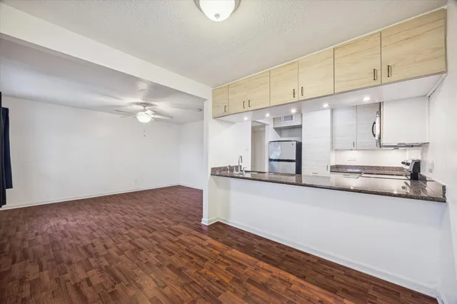 a kitchen with stainless steel appliances a sink cabinets and wooden floor