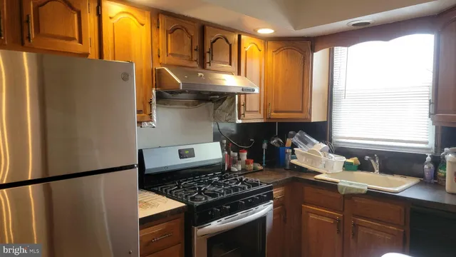 a kitchen with stainless steel appliances granite countertop a refrigerator and a sink