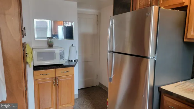 a kitchen with granite countertop a refrigerator and a sink