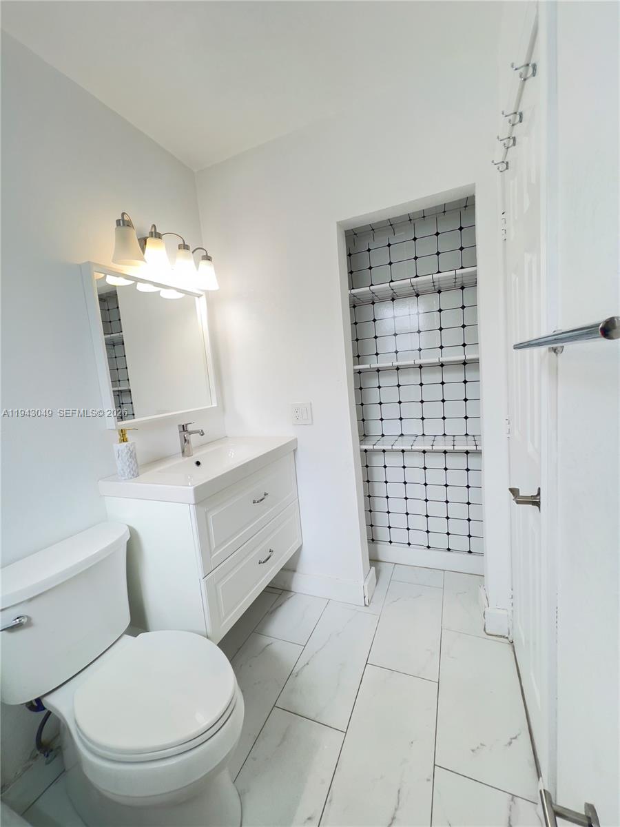 2761 Southwest 33rd Court, Unit A Miami, FL 33133 - Photo 7 of 22 a bathroom with a toilet a sink and a mirror