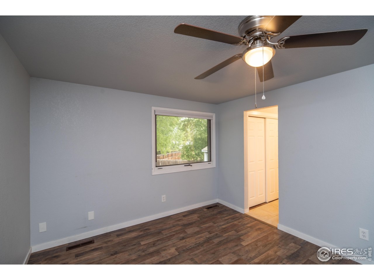 10879 West 65th Way Arvada, CO 80004 - Photo 20 of 39 a view of an empty room and window and wooden floor
