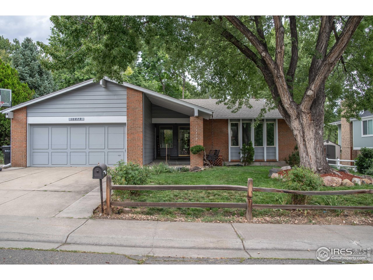10879 West 65th Way Arvada, CO 80004 - Photo 2 of 39 a front view of a house with a yard and a garage