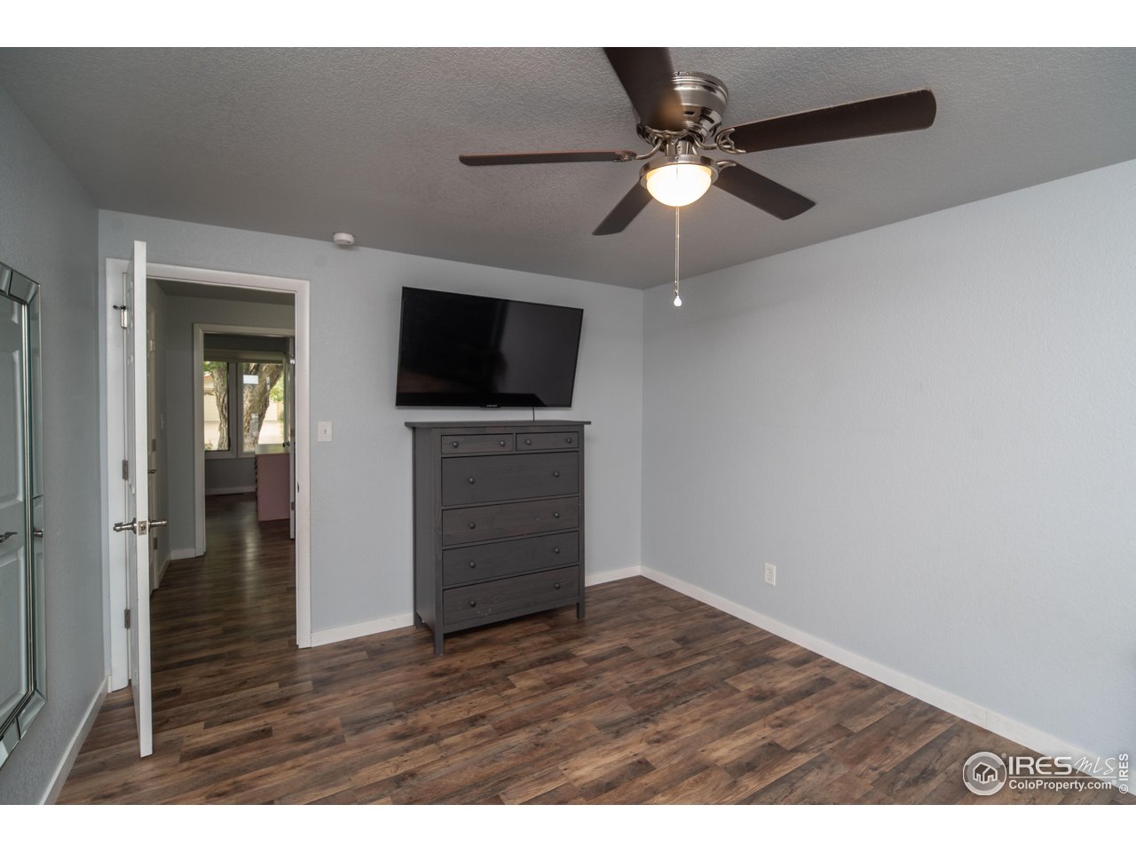 10879 West 65th Way Arvada, CO 80004 - Photo 26 of 39 a view of empty room with wooden floor and fan