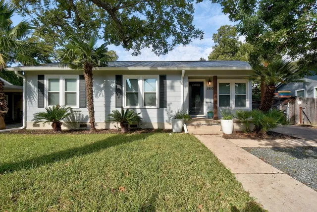 a front view of a house with a garden and patio