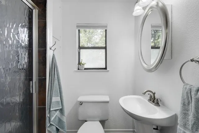 a bathroom with a toilet sink and mirror