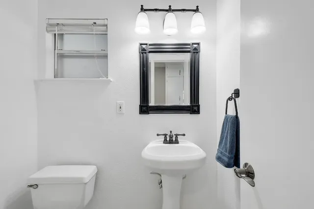 a bathroom with a toilet sink and mirror