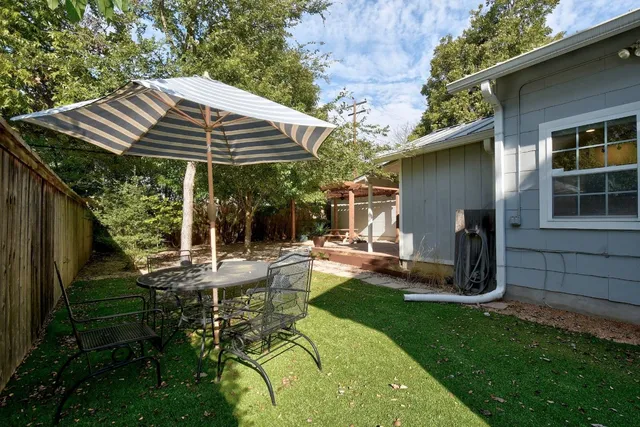 a view of a chair and table in backyard of the house