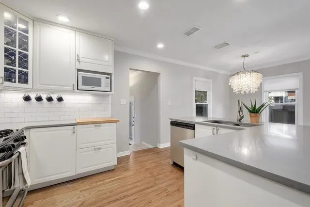 a large kitchen with granite countertop a large counter top appliances and cabinets