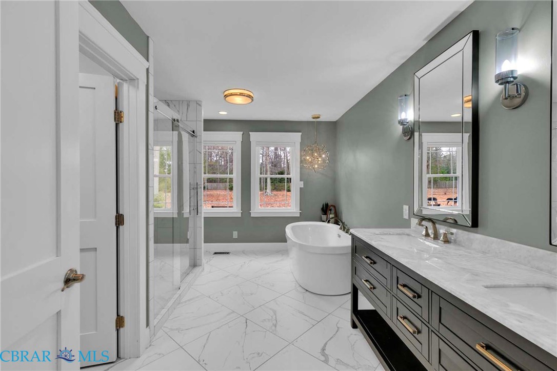 411 Hookemfair Road Cobbs Creek, VA 23035 - Photo 26 of 50 Primary bathroom with marble floors, double vanity, oversized soaking tub and large shower.