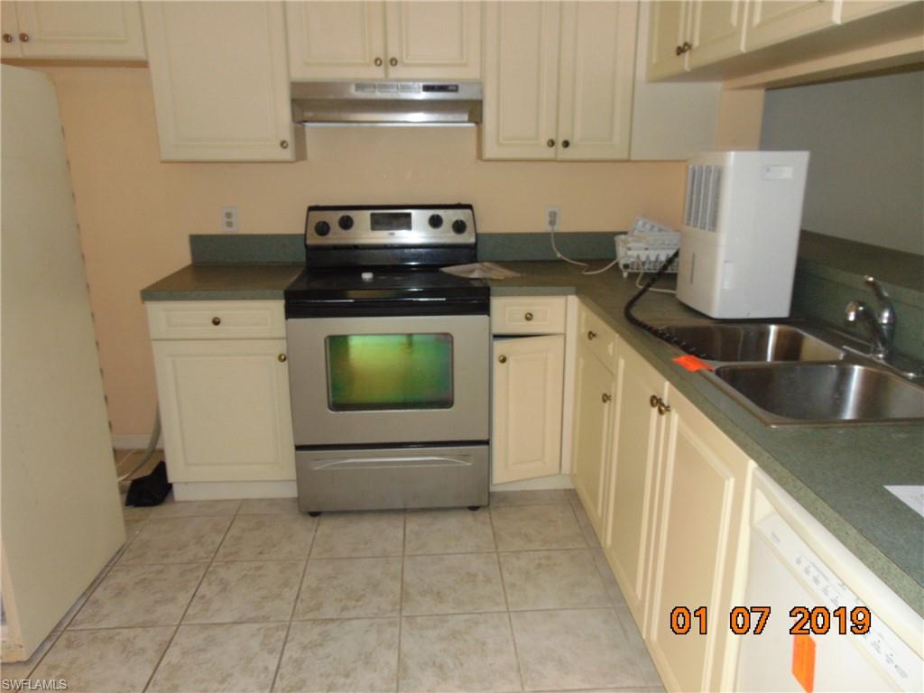 5685 Whitaker Road, Unit C102 Naples, FL 34112 - Photo 2 of 10 a kitchen with a stove and a sink