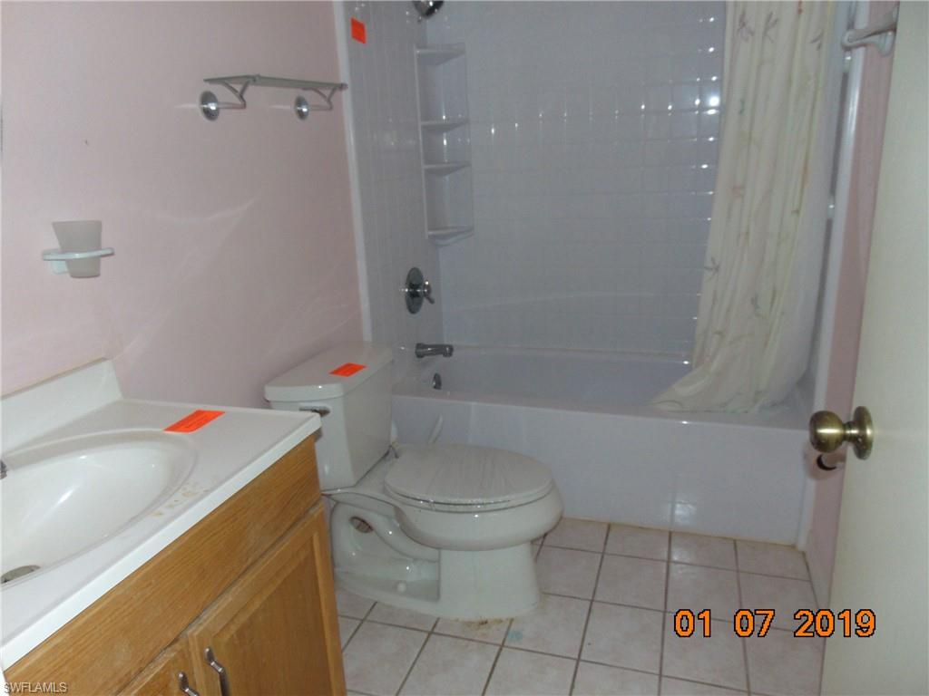 5685 Whitaker Road, Unit C102 Naples, FL 34112 - Photo 3 of 10 a bathroom with a sink a toilet and shower