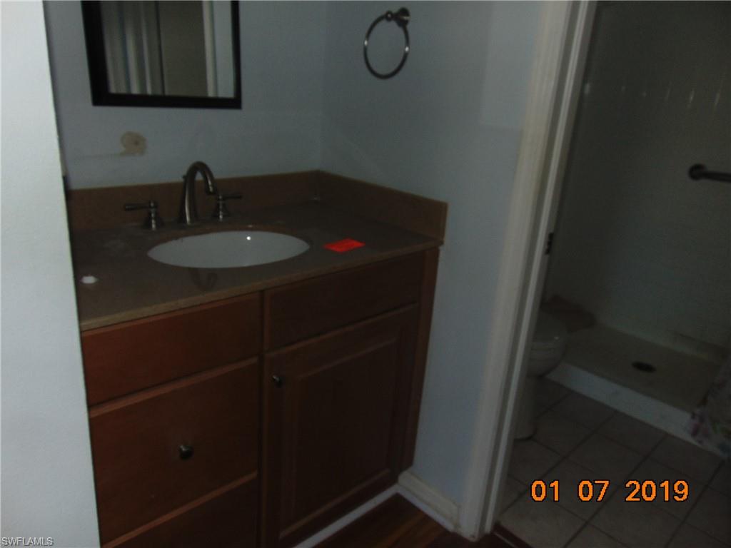 5685 Whitaker Road, Unit C102 Naples, FL 34112 - Photo 7 of 10 a bathroom with a sink and a mirror
