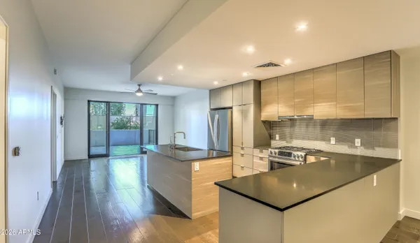 a kitchen with stainless steel appliances granite countertop a sink a stove and a refrigerator