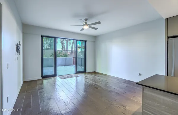 an empty room with wooden floor and windows