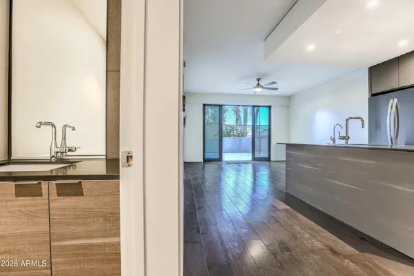 a view of a hallway with wooden floor and a living room