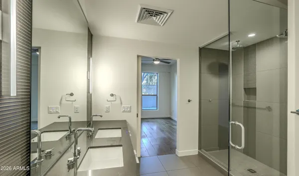 a bathroom with a granite countertop tub shower and mirror