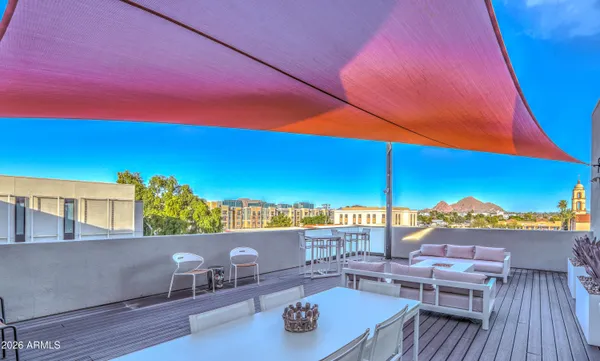 a view of roof deck with seating space and city view