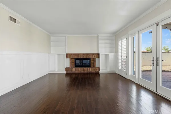 an empty room with wooden floor and fireplace