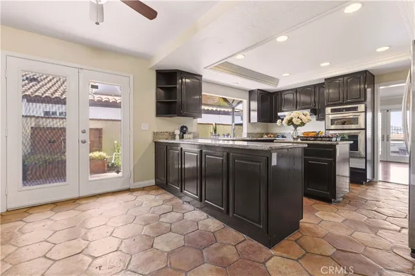 a kitchen with stainless steel appliances granite countertop a stove a sink and a refrigerator