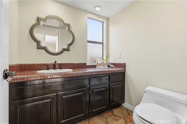 a bathroom with a granite countertop toilet sink and mirror