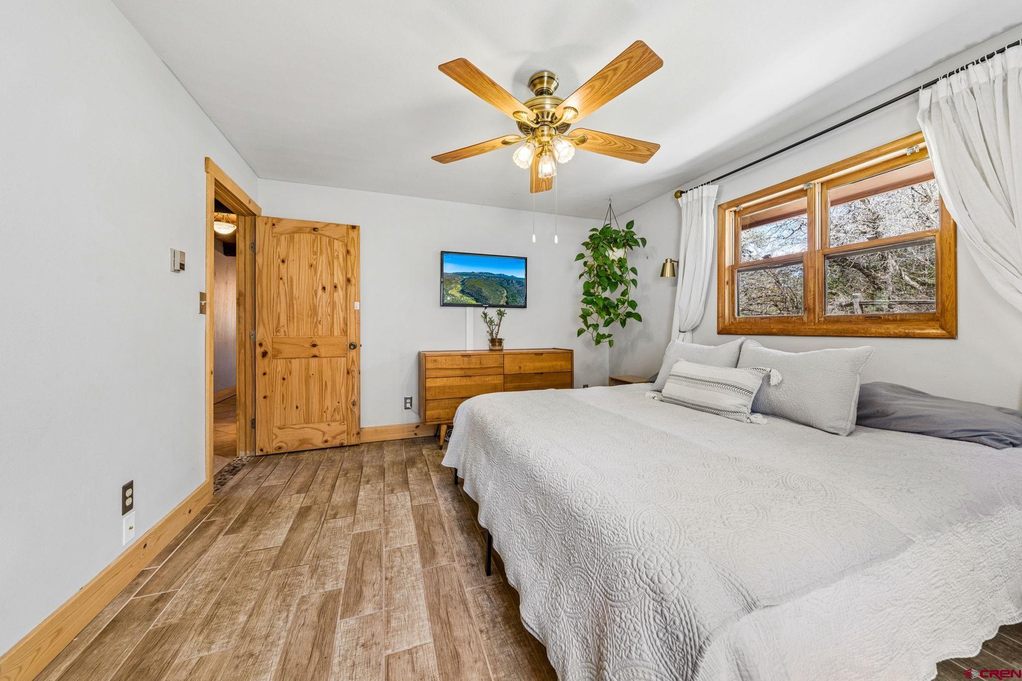 511 High Trails Drive Durango, CO 81301 - Photo 18 of 45 a bedroom with a large bed and a chandelier