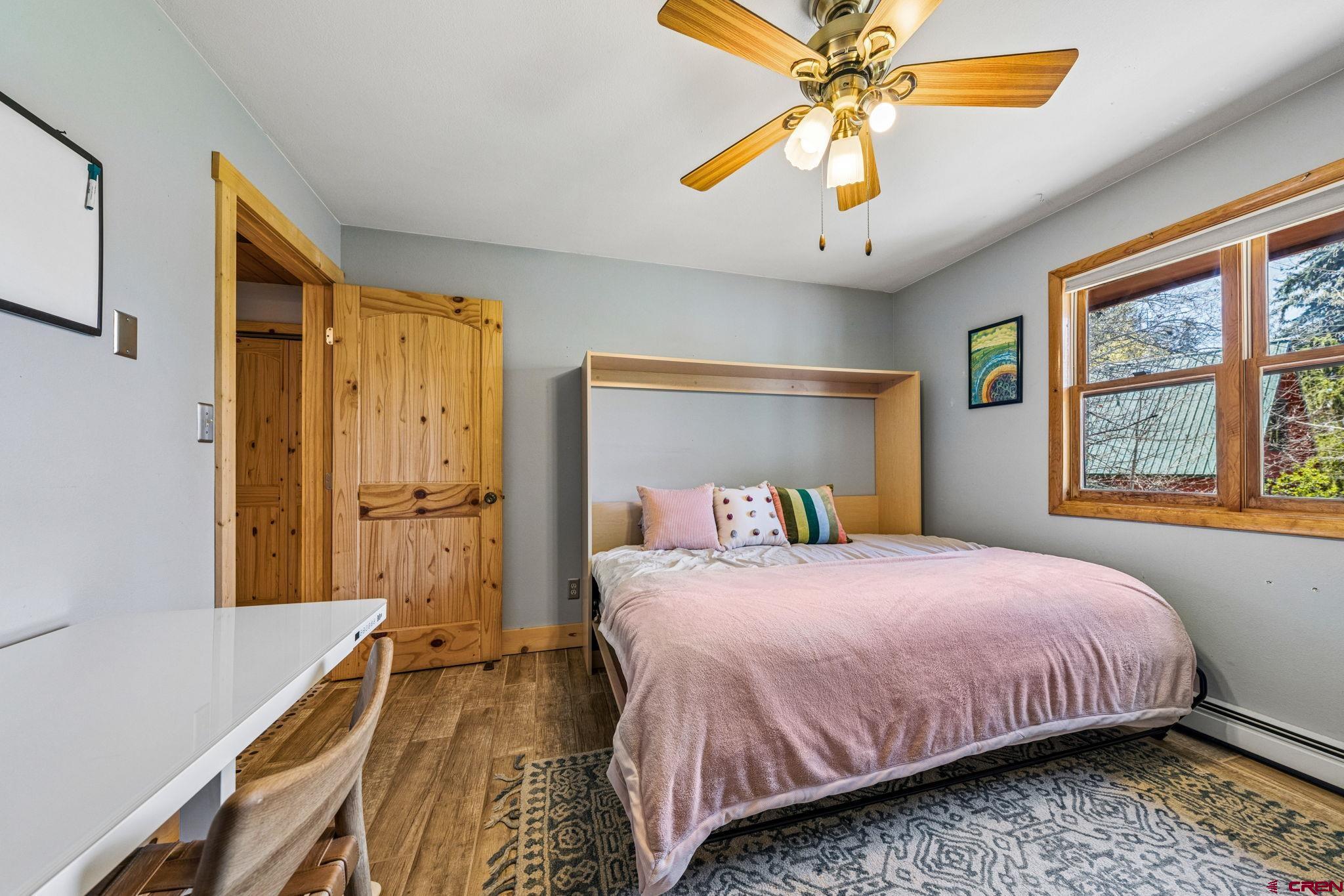 511 High Trails Drive Durango, CO 81301 - Photo 25 of 45 a bedroom with a bed and a chandelier