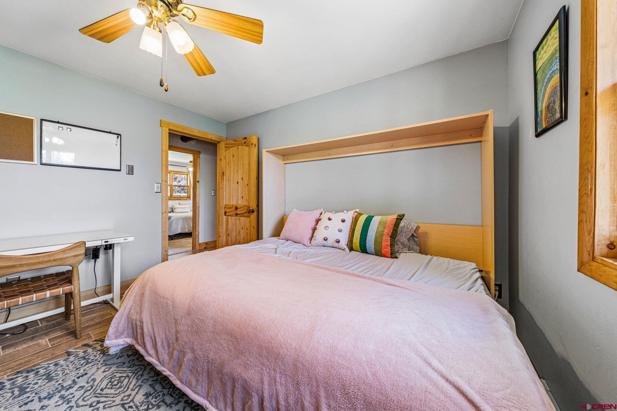 511 High Trails Drive Durango, CO 81301 - Photo 27 of 45 a bedroom with a bed and a chandelier