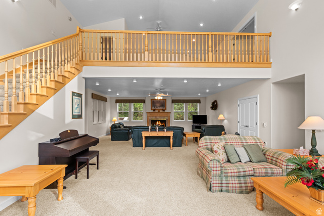 1133 Paris Canyon Road Paris, ID 83261 - Photo 4 of 74 Two-story living area featuring a wood staircase with carpeted treads, a second-story balcony with wood railing, recessed lighting, and a stone-clad fireplace