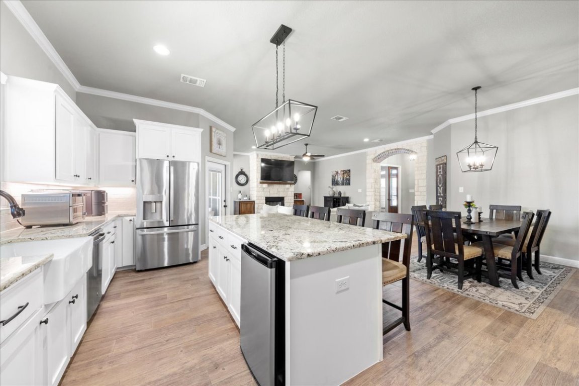 3810 Green Tree Loop Temple, TX 76502 - Photo 14 of 40 a kitchen with stainless steel appliances kitchen island granite countertop a table chairs sink and cabinets