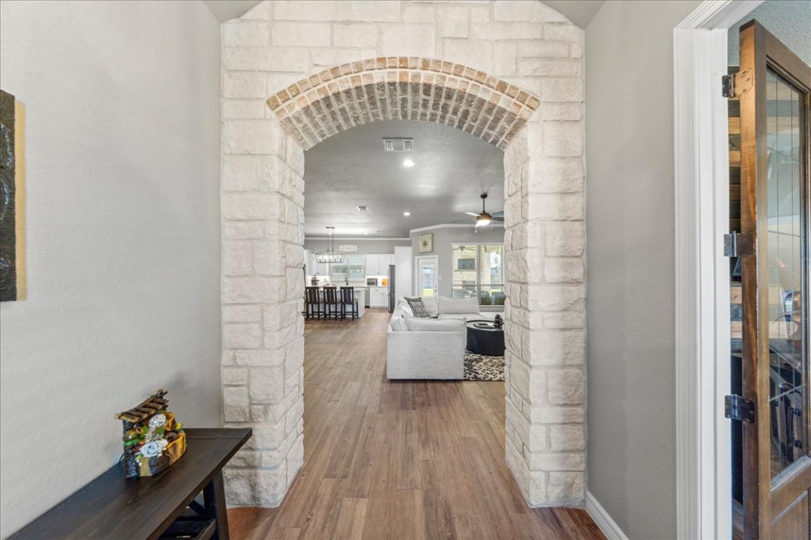 3810 Green Tree Loop Temple, TX 76502 - Photo 5 of 40 Hall featuring arched walkways, wood finished floors, and a textured wall