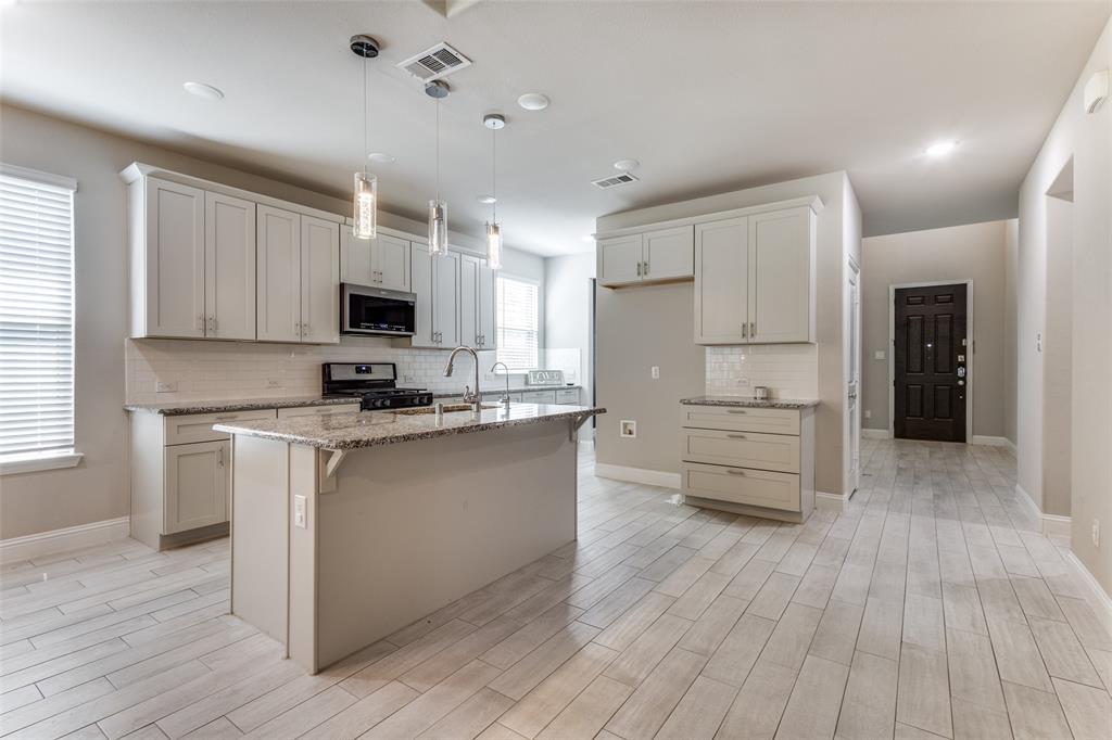 2912 Inn Kitchen Way McKinney, TX 75071 - Photo 2 of 29 a kitchen with stainless steel appliances a refrigerator sink and cabinets