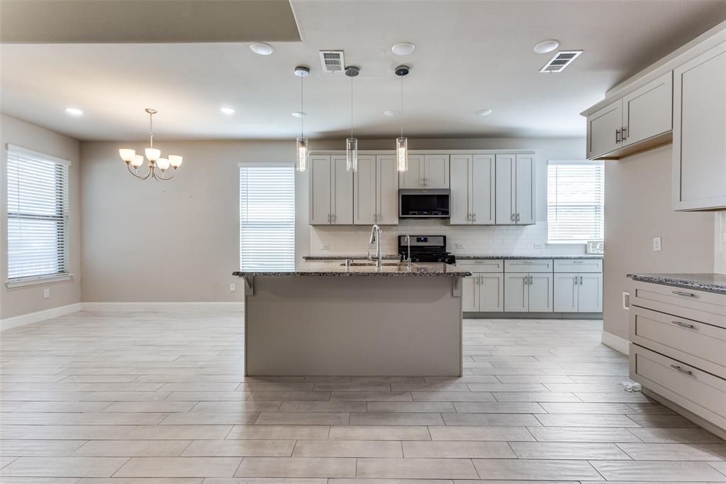 2912 Inn Kitchen Way McKinney, TX 75071 - Photo 7 of 29 a large kitchen with cabinets a sink a window and stainless steel appliances