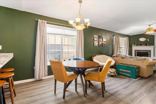 a dining room with furniture a chandelier and wooden floor