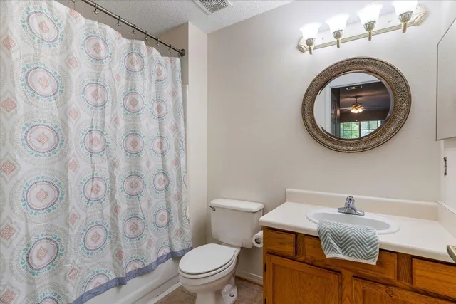 a bathroom with a granite countertop toilet and a sink
