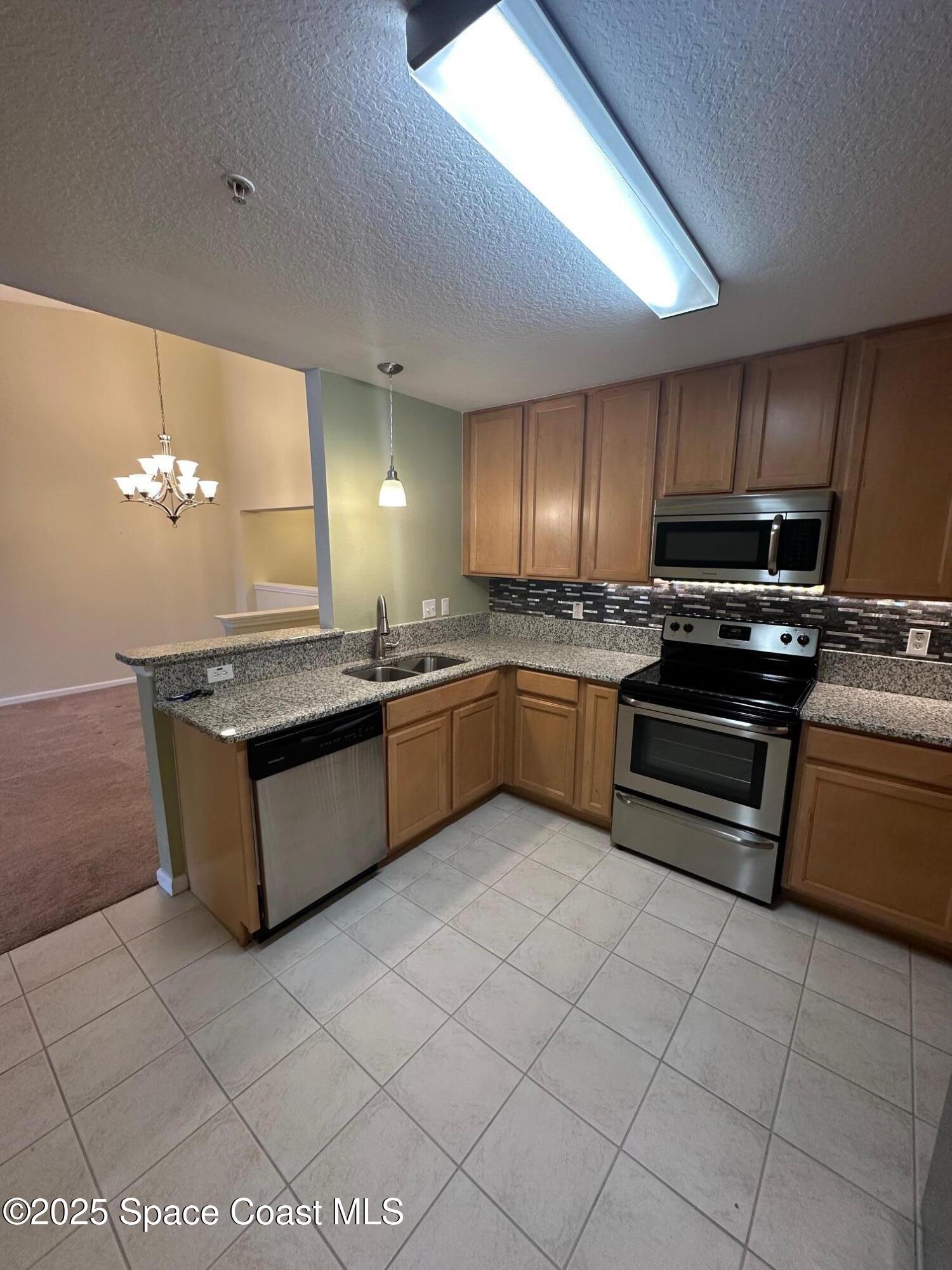 4106 Meander Place, Unit 208 Rockledge, FL 32955 - Photo 5 of 19 a kitchen with stainless steel appliances granite countertop a stove sink and cabinets