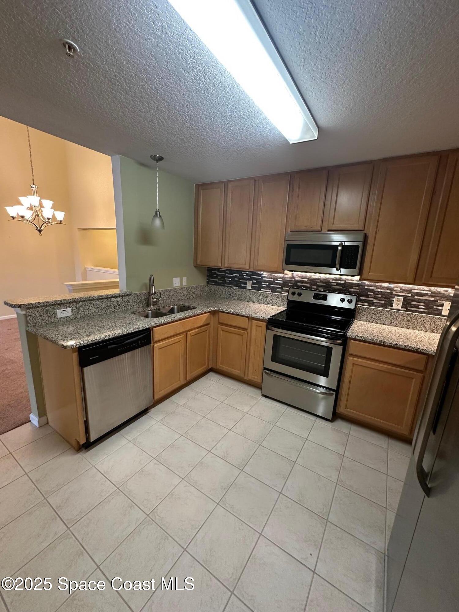 4106 Meander Place, Unit 208 Rockledge, FL 32955 - Photo 6 of 19 a kitchen with stainless steel appliances granite countertop a stove sink and cabinets