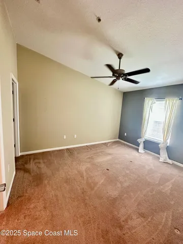 a view of a room with a ceiling fan and window