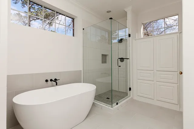 a white bath tub sitting next to a shower