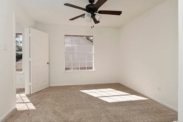a view of a room with a window and a ceiling fan