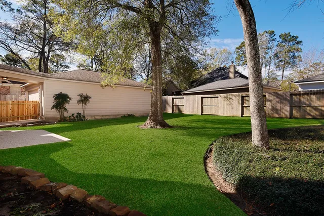 a front view of a house with a garden and trees