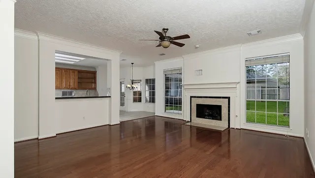 a living room with wooden floor and a fireplace