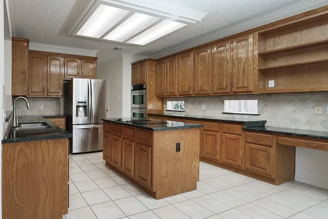 a kitchen with stainless steel appliances granite countertop a sink counter space cabinets and a large window