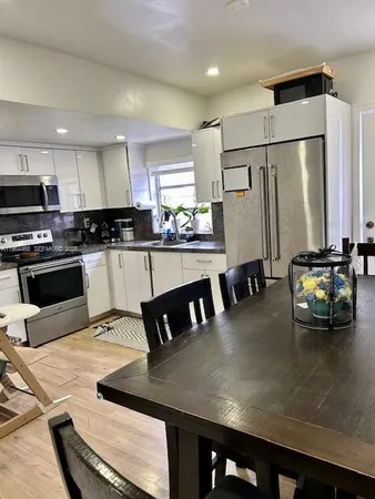 a kitchen with stainless steel appliances granite countertop a stove a refrigerator a microwave a sink and white cabinets