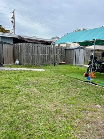 a view of a backyard with wooden fence