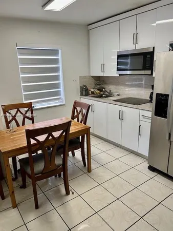 a kitchen with a chair and cabinets