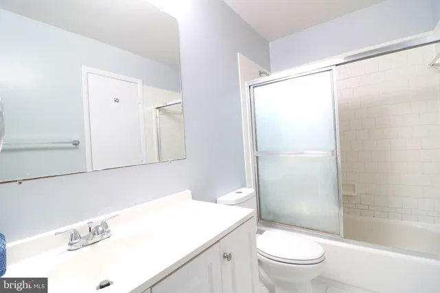 a bathroom with a sink a mirror toilet and shower